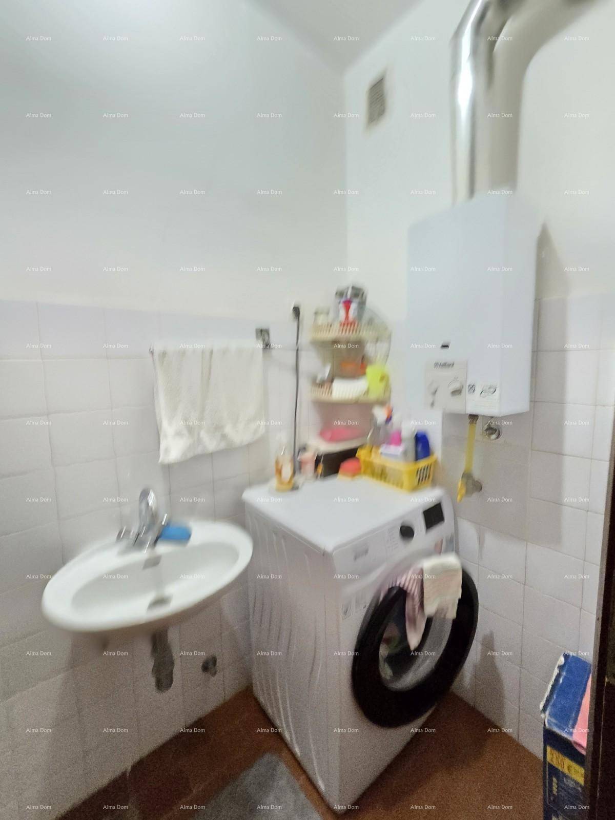 Funktionaler Waschraum mit Waschmaschine, Waschbecken und Warmwasserbereiter.