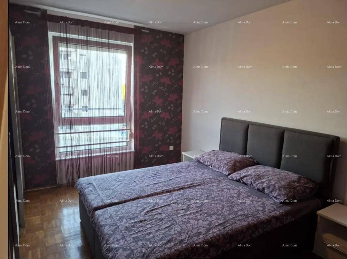 Schlafzimmer mit Doppelbett, Parkettboden und einer Wand mit floraler Tapete.