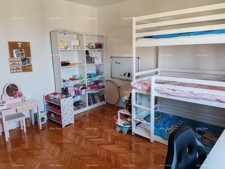 Geräumiges Kinderzimmer mit Etagenbett, Spielbereich und viel Stauraum.