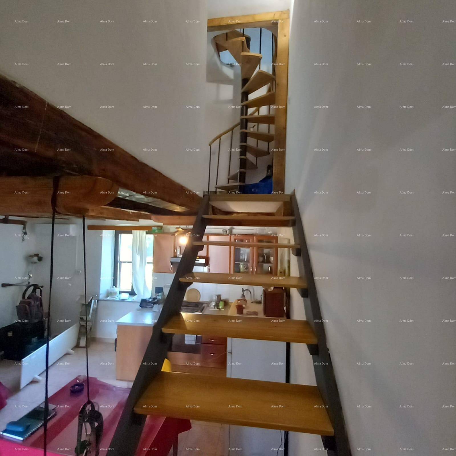 Innenansicht mit Holztreppen, die zu einem oberen Bereich und einer Wendeltreppe führen.