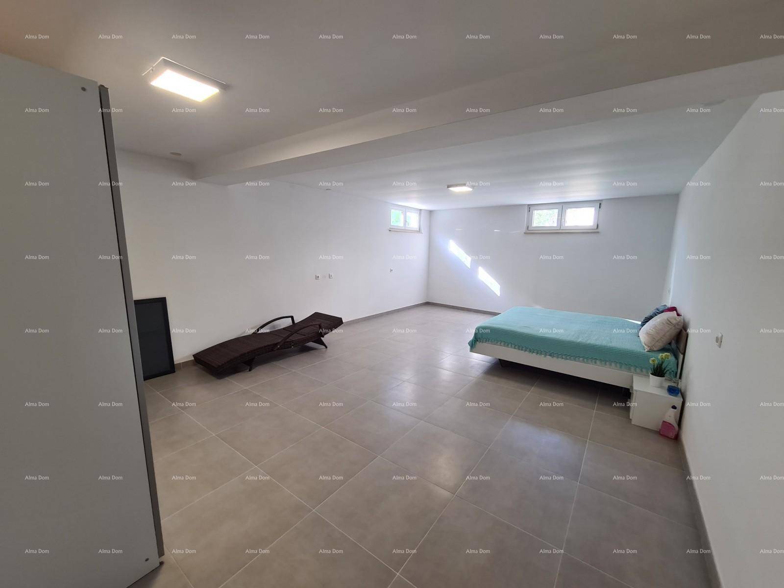 Geräumiger Kellerraum mit Fliesenboden, Bett und kleinen Fenstern.