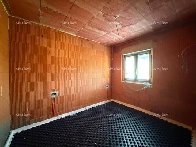 Unfertiges Schlafzimmer mit Ziegelwänden, Fußbodenheizungsvorbereitung und Fenster für natürliches Licht.