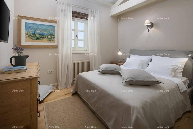 Gemütliches Schlafzimmer mit Holzboden, Doppelbett und Kunstwerk an der Wand.