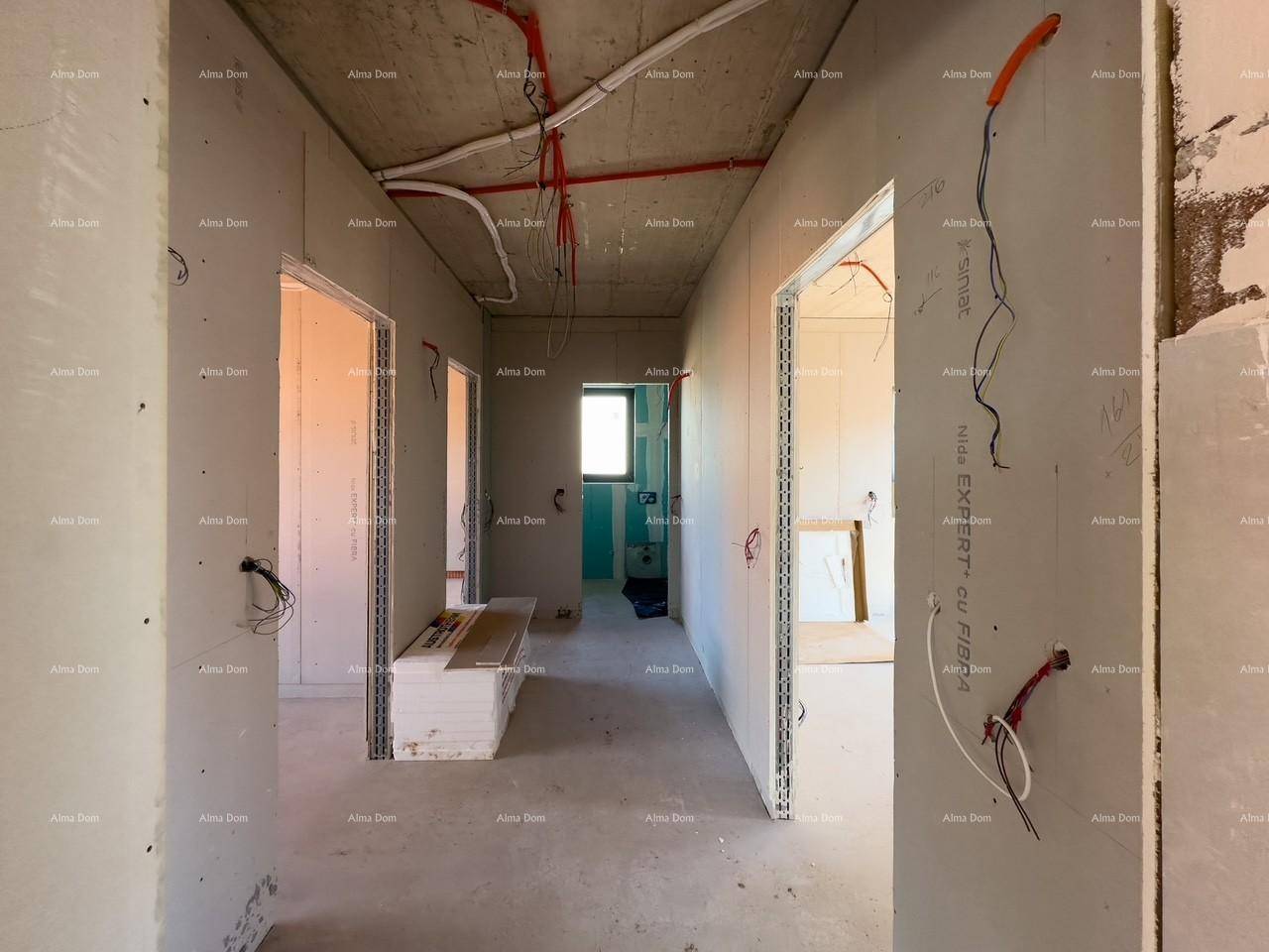 Flur im Rohbau mit mehreren Türöffnungen und sichtbaren Elektroinstallationen an der Betondecke.