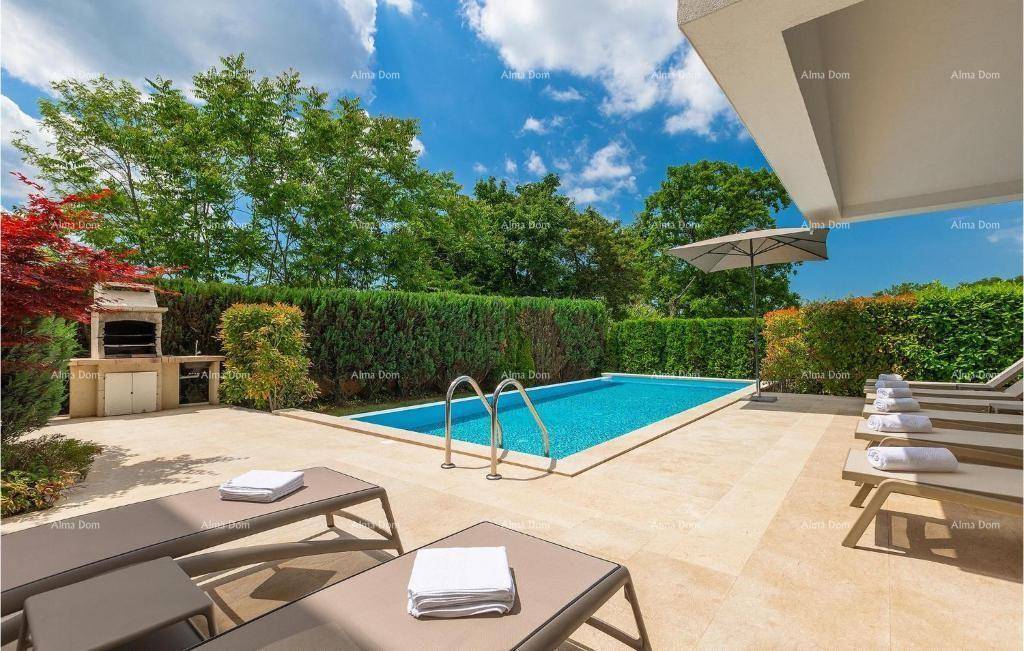 Großzügiger Poolbereich mit Sonnenliegen und einem integrierten Grillplatz, umgeben von einer grünen Hecke.