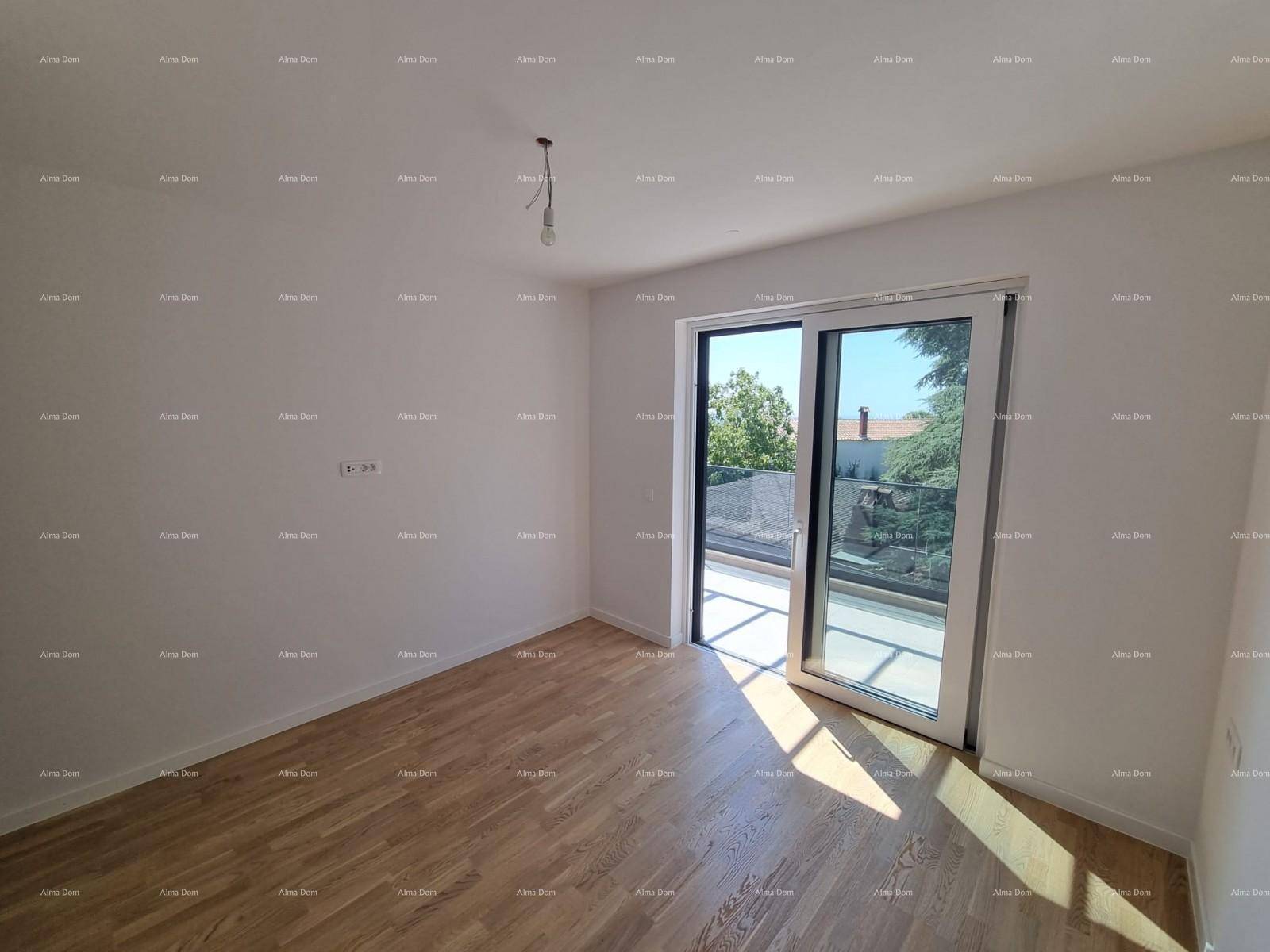Schlafzimmer mit Parkettboden und großen Fenstern, die viel Licht hereinlassen.