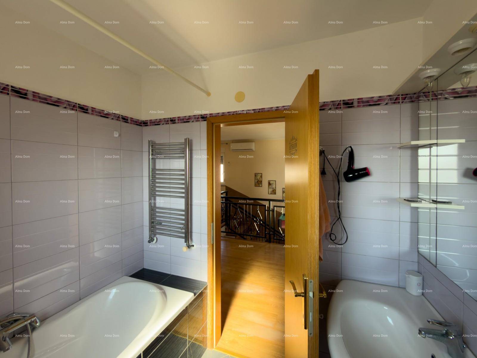 Funktionales Badezimmer mit Badewanne, Waschbecken und beheiztem Handtuchhalter.