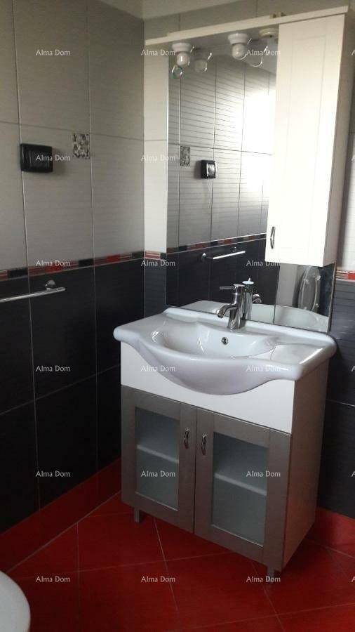 Badezimmer mit modernem Waschbecken, Spiegelschrank und roten Bodenfliesen.