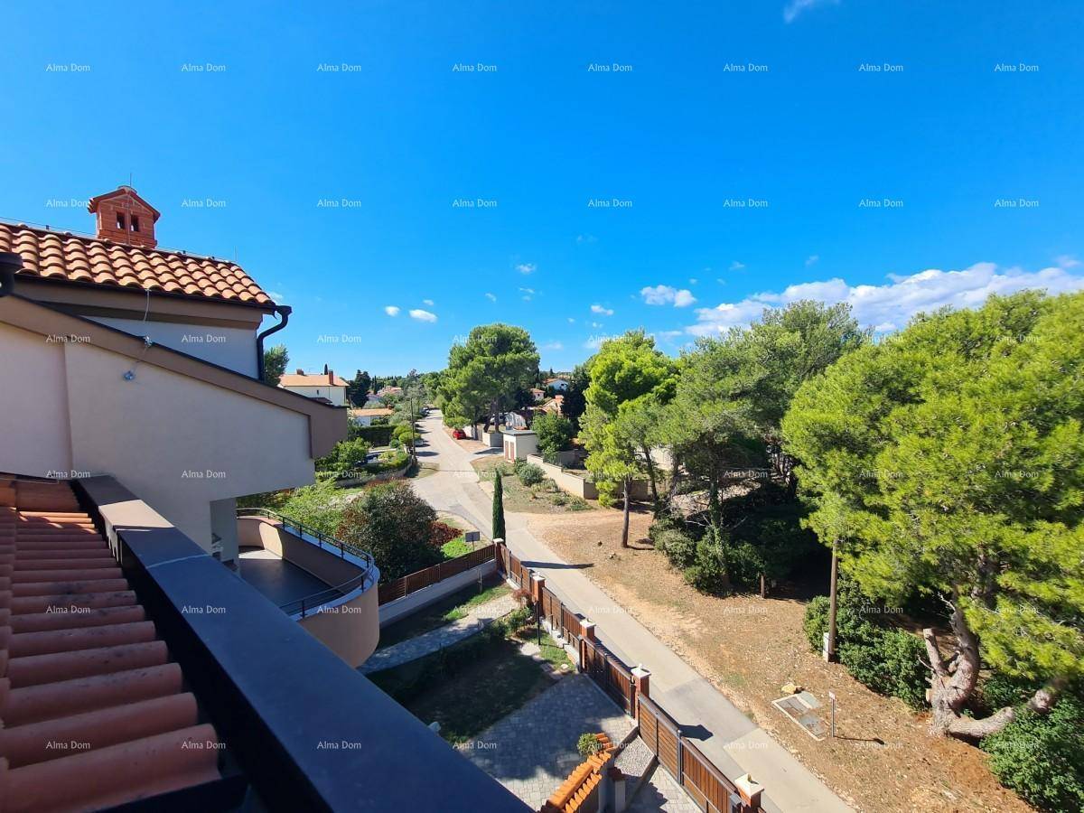 Ausblick von einem Balkon auf eine ruhige Wohnstraße mit Häusern und üppiger Vegetation.