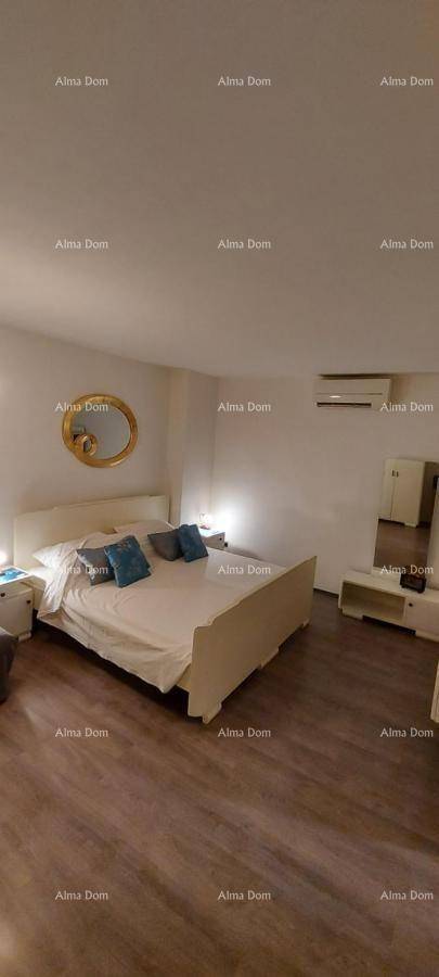 Geräumiges Schlafzimmer mit großem Bett, Holzboden und Klimaanlage.