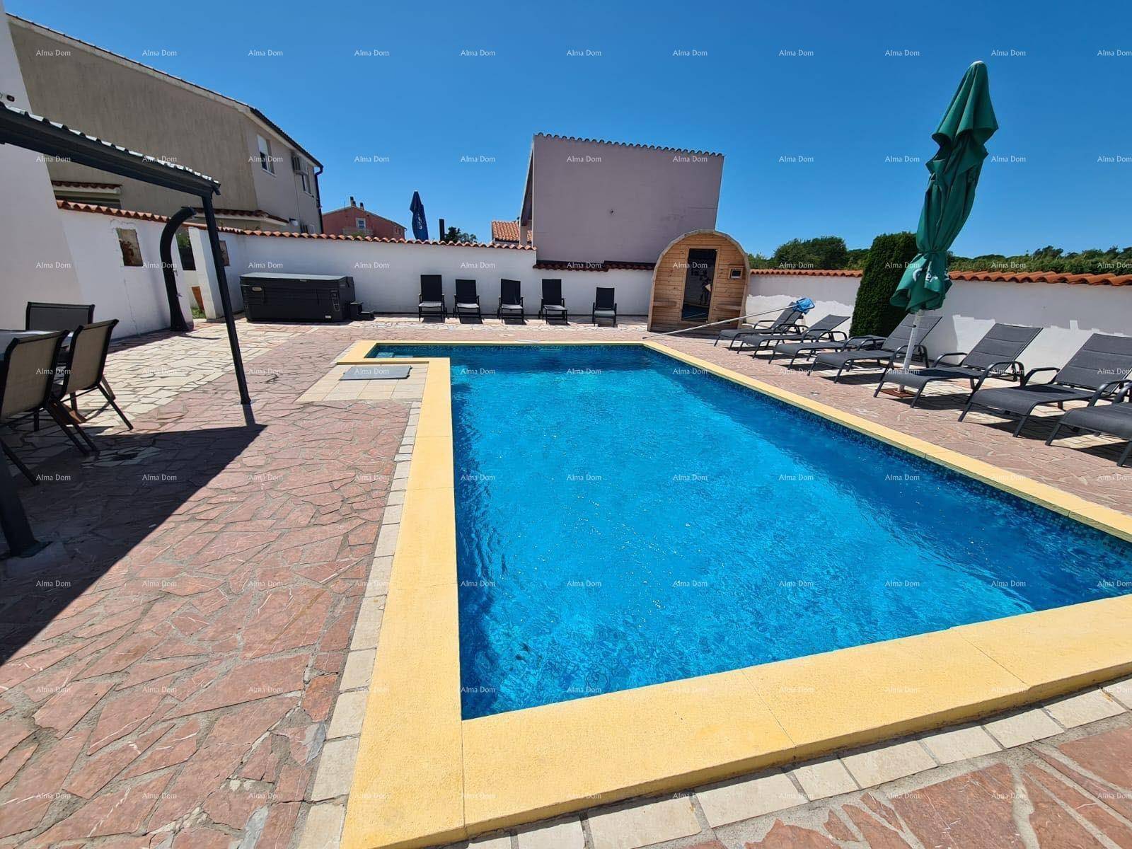 Außenbereich mit großem Pool, Liegestühlen, Sauna und Whirlpool für Entspannung.