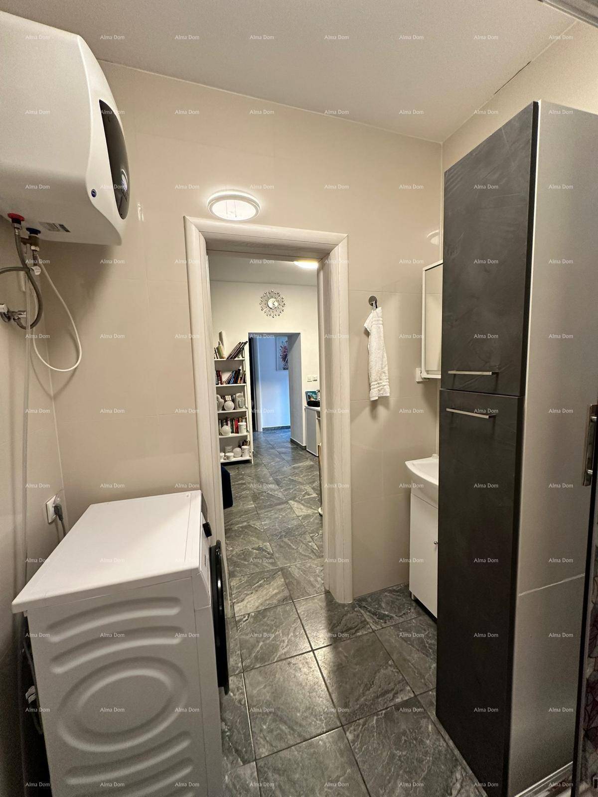 Funktionaler Flur mit Waschmaschine, Warmwasserbereiter und Zugang zu weiteren Wohnbereichen.