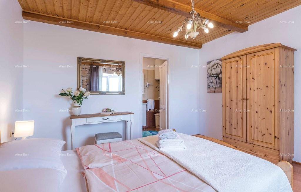 Schlafzimmer mit Holzbalkendecke, Kleiderschrank und Zugang zu einem Badezimmer.
