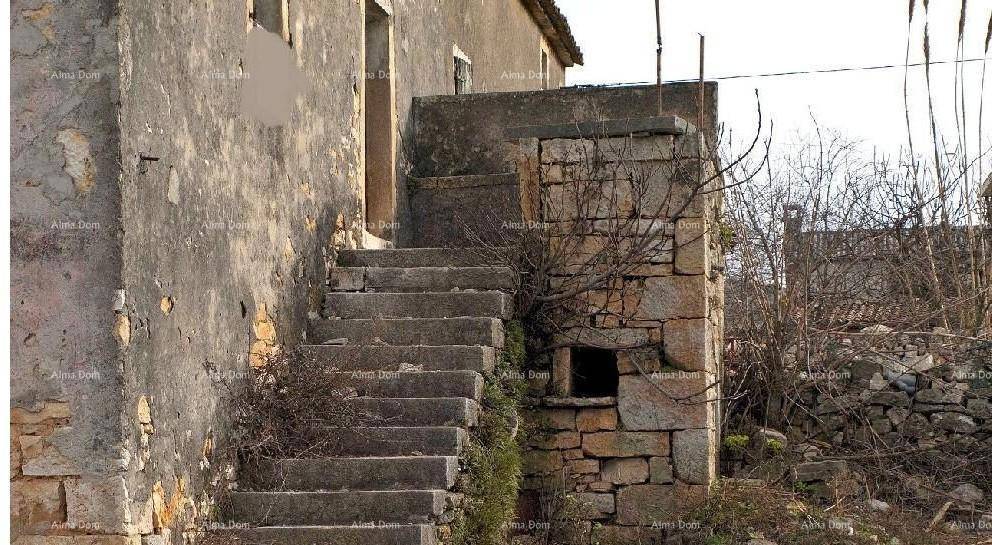 Außenansicht des alten Steinhauses mit verwitterten Steintreppen, die zu einem oberen Eingang führen.
