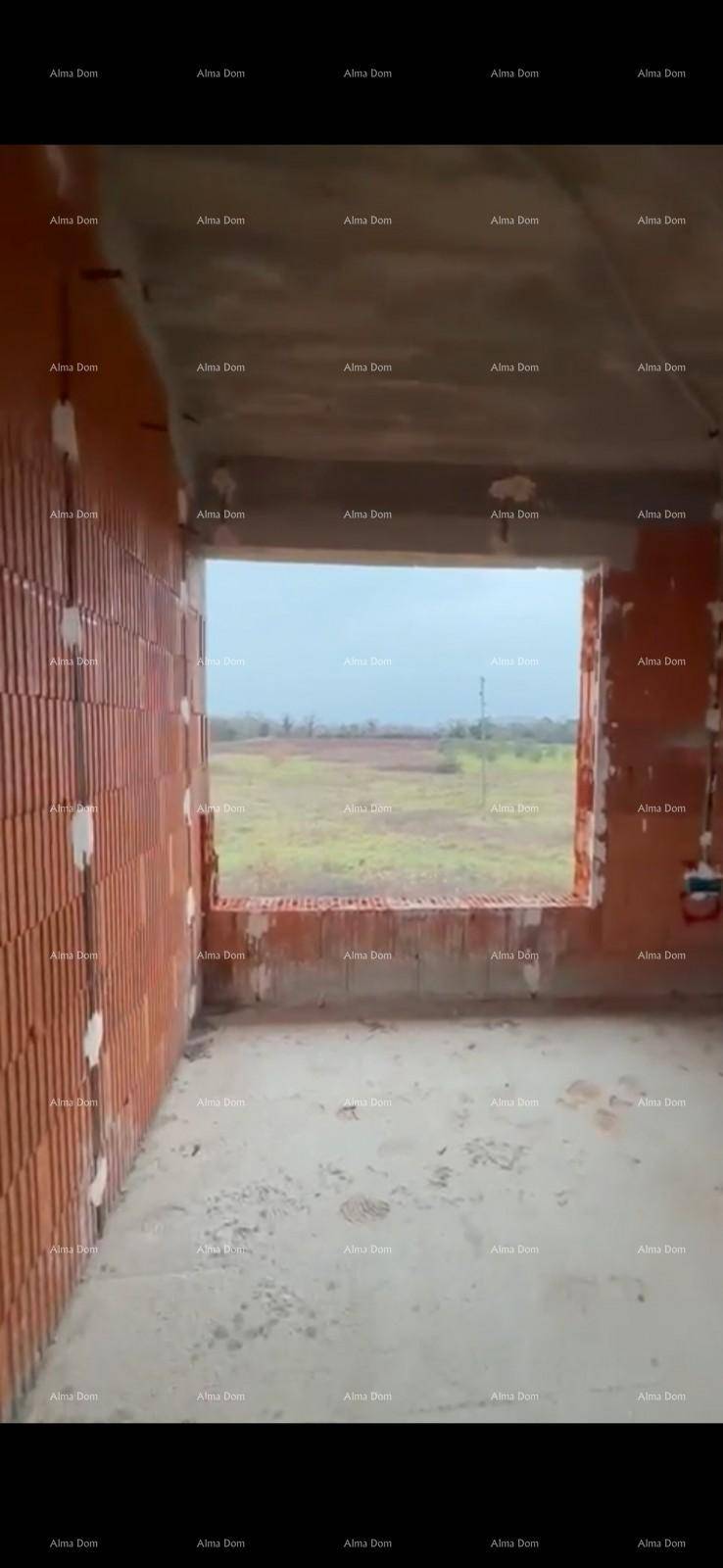 Rohbau-Innenraum mit großer Fensteröffnung und weitem Blick über die Felder.