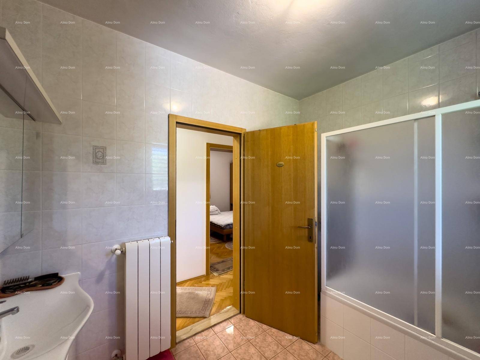 Badezimmer mit Duschkabine und Heizkörper, mit Blick in ein angrenzendes Schlafzimmer.
