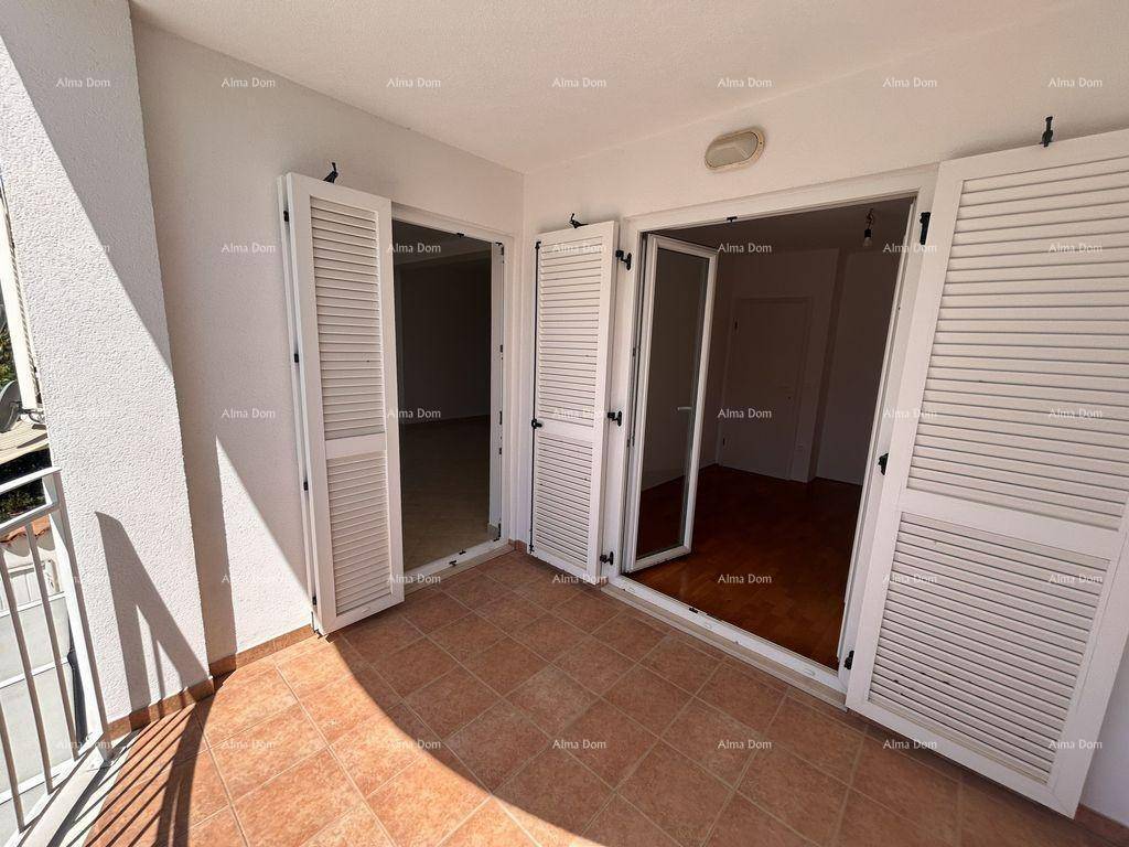 Geräumiger Balkon mit Fliesenboden und weißen Fensterläden, bietet Zugang zu den Innenräumen.