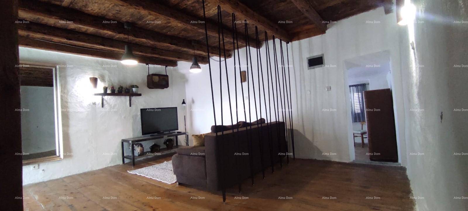 Rustikales Wohnzimmer mit freiliegenden Holzbalken, Holzboden und einem gemütlichen Sofa.
