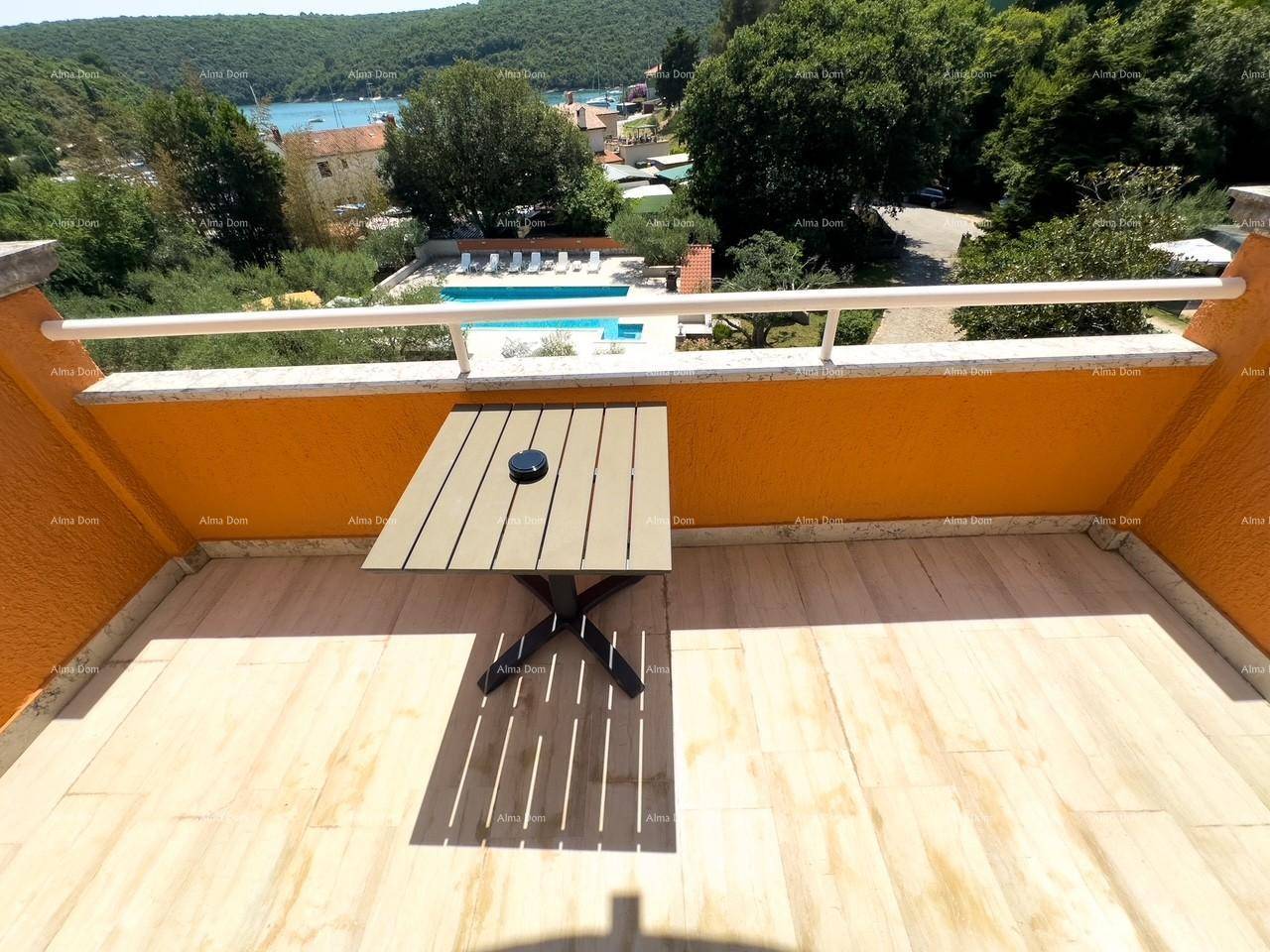 Balkon mit kleinem Tisch und Blick auf den Poolbereich und die umliegende Landschaft.