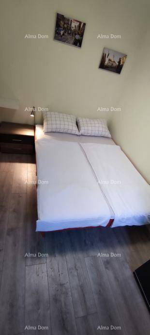 Schlafzimmer mit Doppelbett und Holzboden, bietet eine ruhige Atmosphäre zum Entspannen.