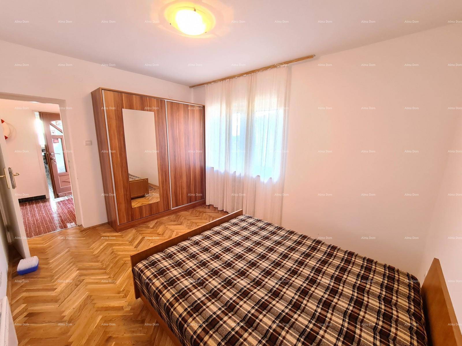 Schlafzimmer mit Parkettboden, Doppelbett und Kleiderschrank mit Spiegeltür.