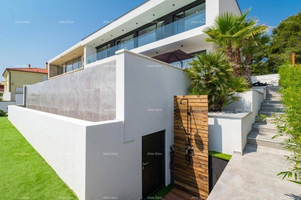 Seitlicher Zugang zur modernen Villa mit Außendusche und Treppen zum Gartenbereich.