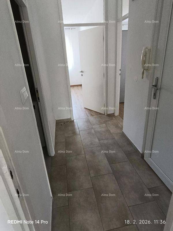 Heller Flur mit Fliesenboden, der zu den verschiedenen Räumen der Wohnung führt.