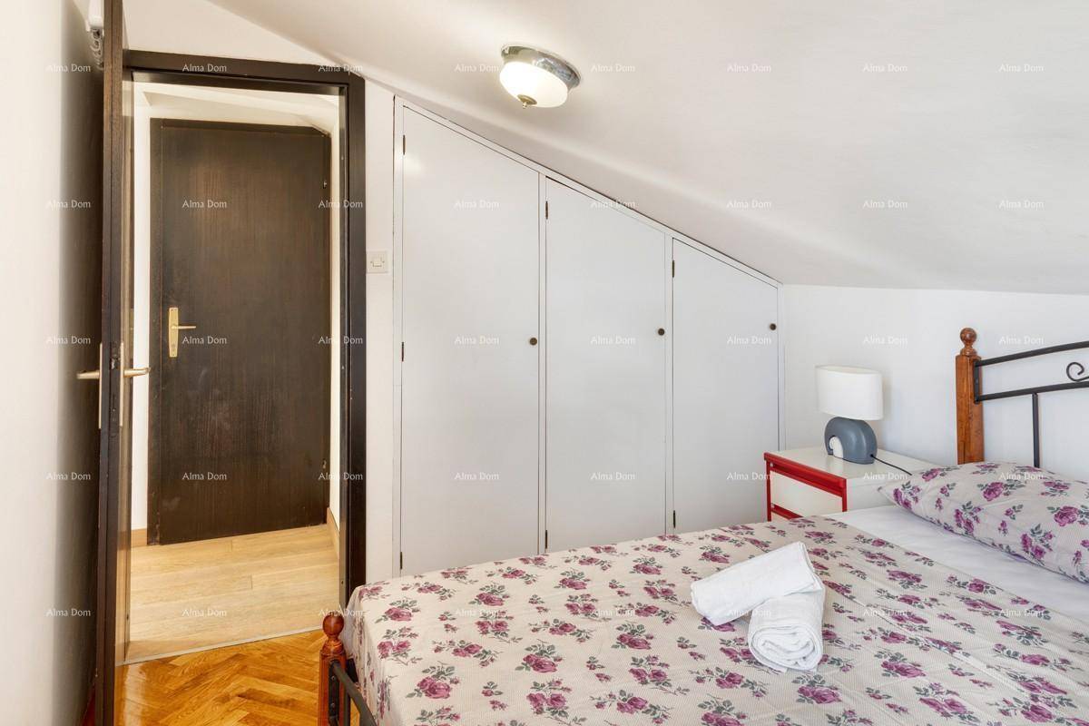 Schlafzimmer im Dachgeschoss mit Doppelbett und Einbauschränken unter der Dachschräge.