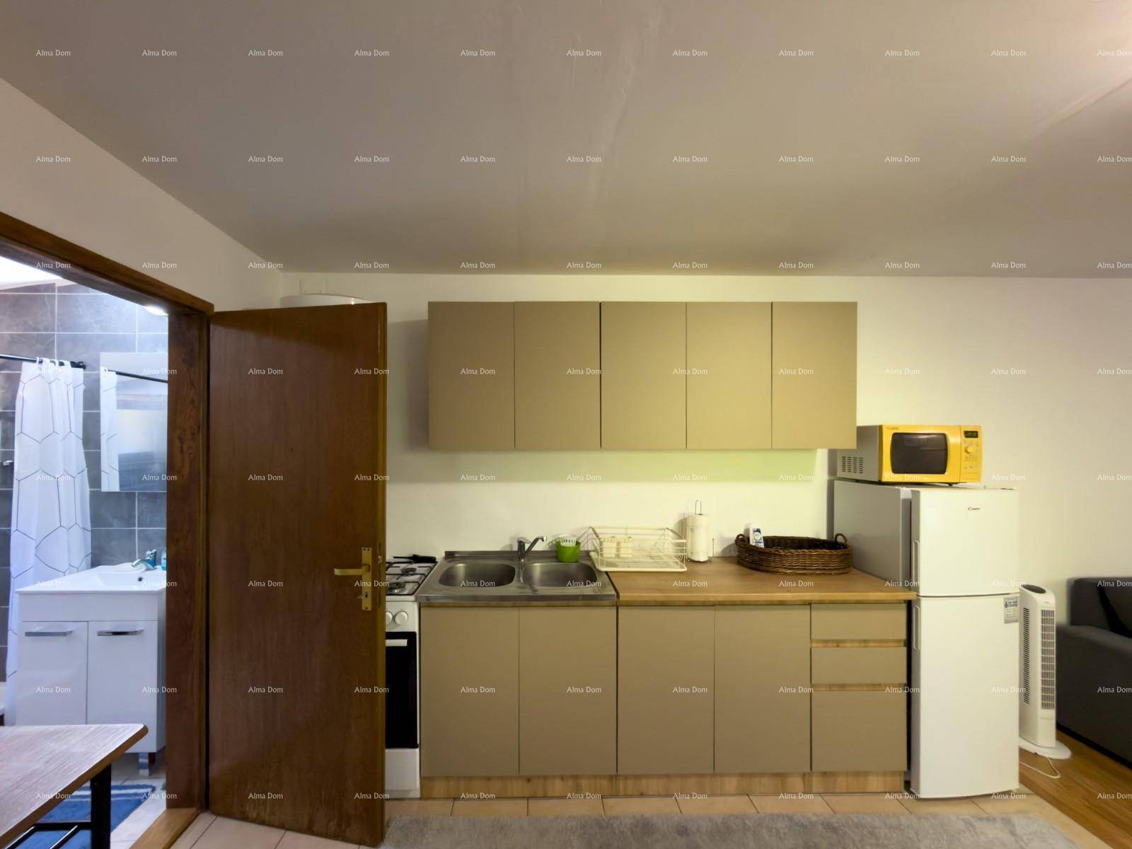 Kompakte Küchenzeile mit Gasherd und Blick in das angrenzende Badezimmer.