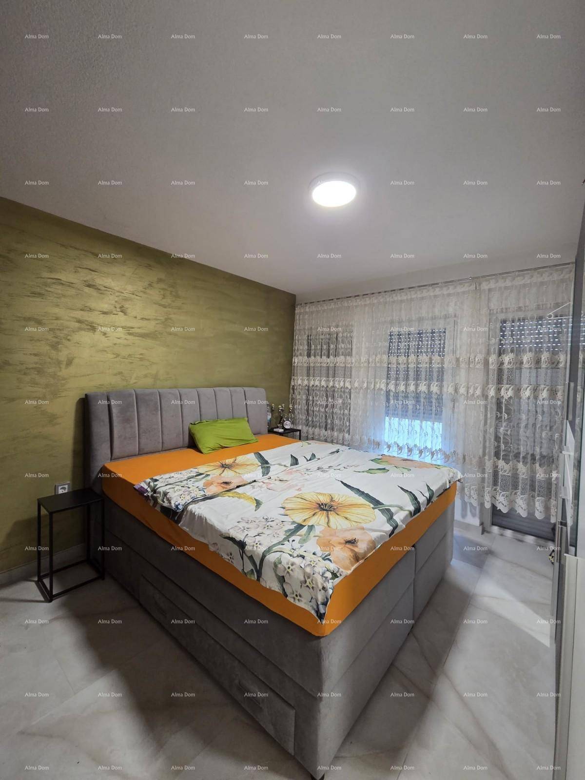 Helles Schlafzimmer mit Doppelbett, Kleiderschrank und farbiger Akzentwand.