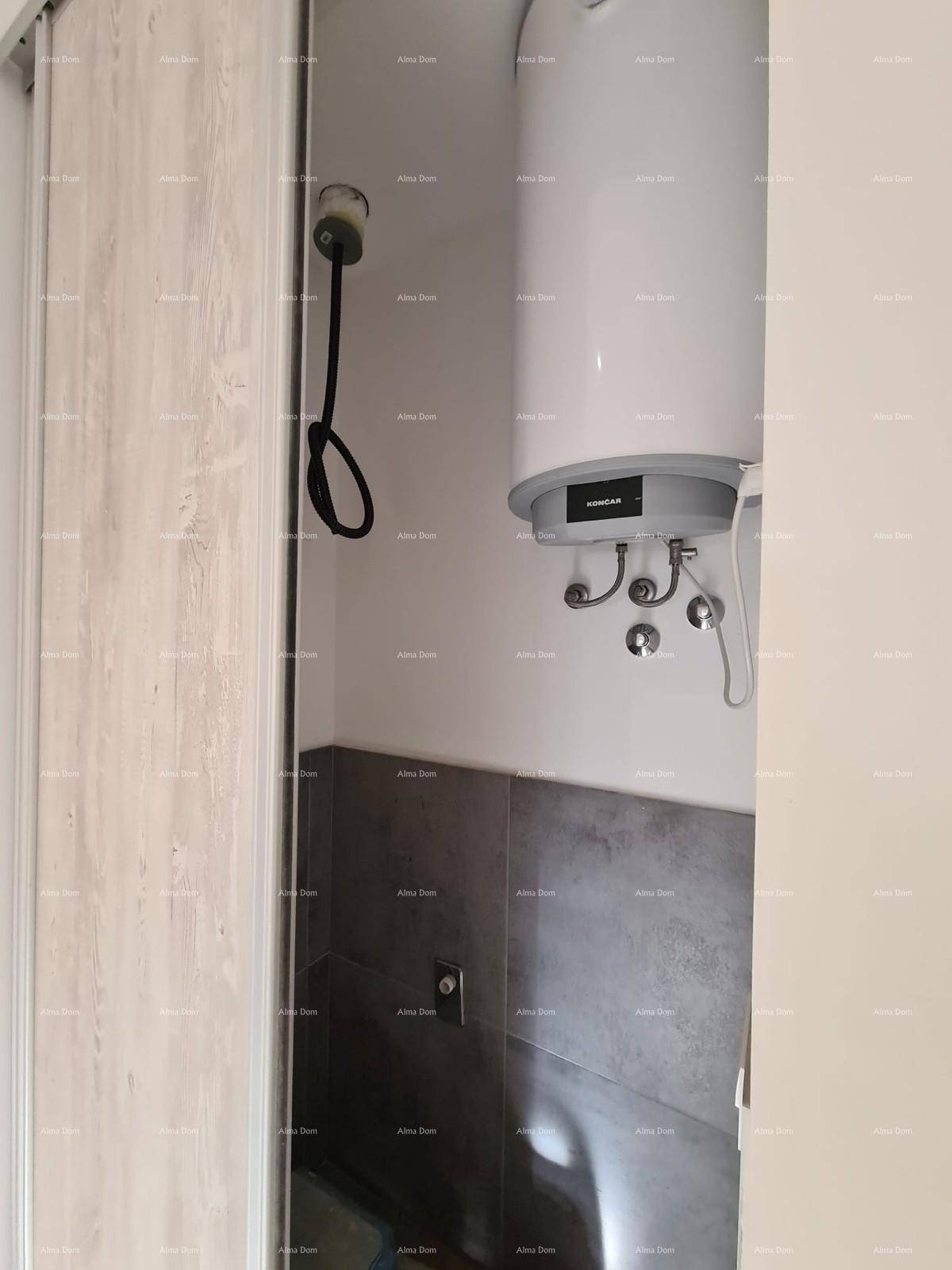 Kleiner Abstellraum mit Warmwasserboiler und Anschluss für eine Waschmaschine.