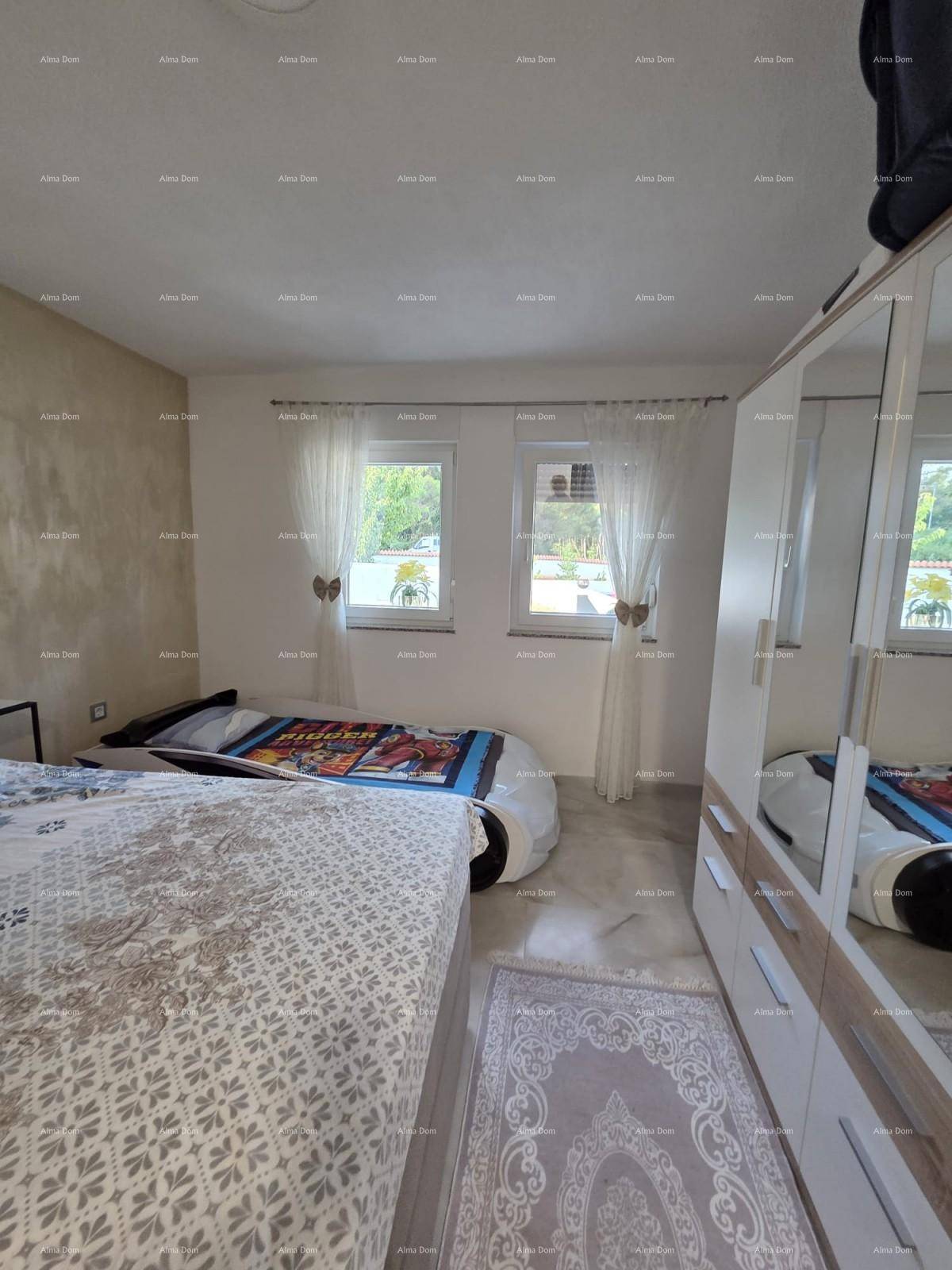 Helles Schlafzimmer mit Doppelbett, Kleiderschrank und zwei Fenstern für viel Tageslicht.