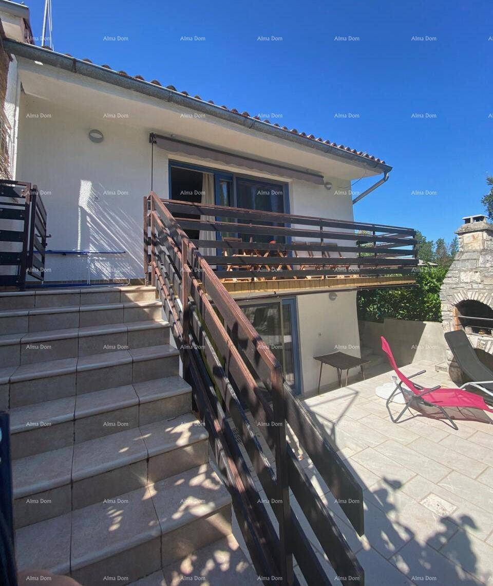 Außenansicht des Hauses mit Balkon, Terrasse und Außentreppe, inklusive Grillbereich.