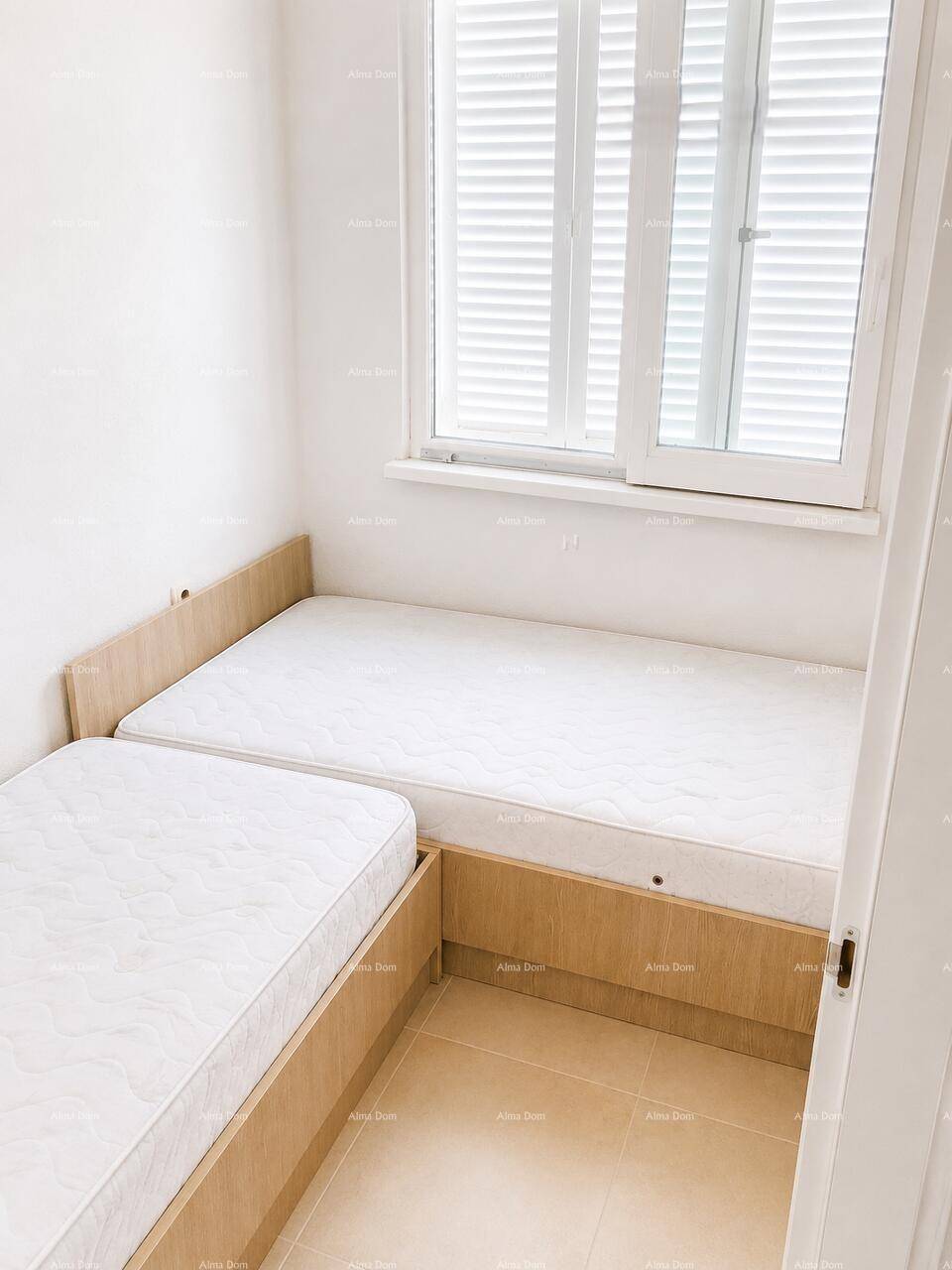 Kleines Schlafzimmer mit zwei Einzelbetten und Fenster mit Fensterläden, bietet Privatsphäre.