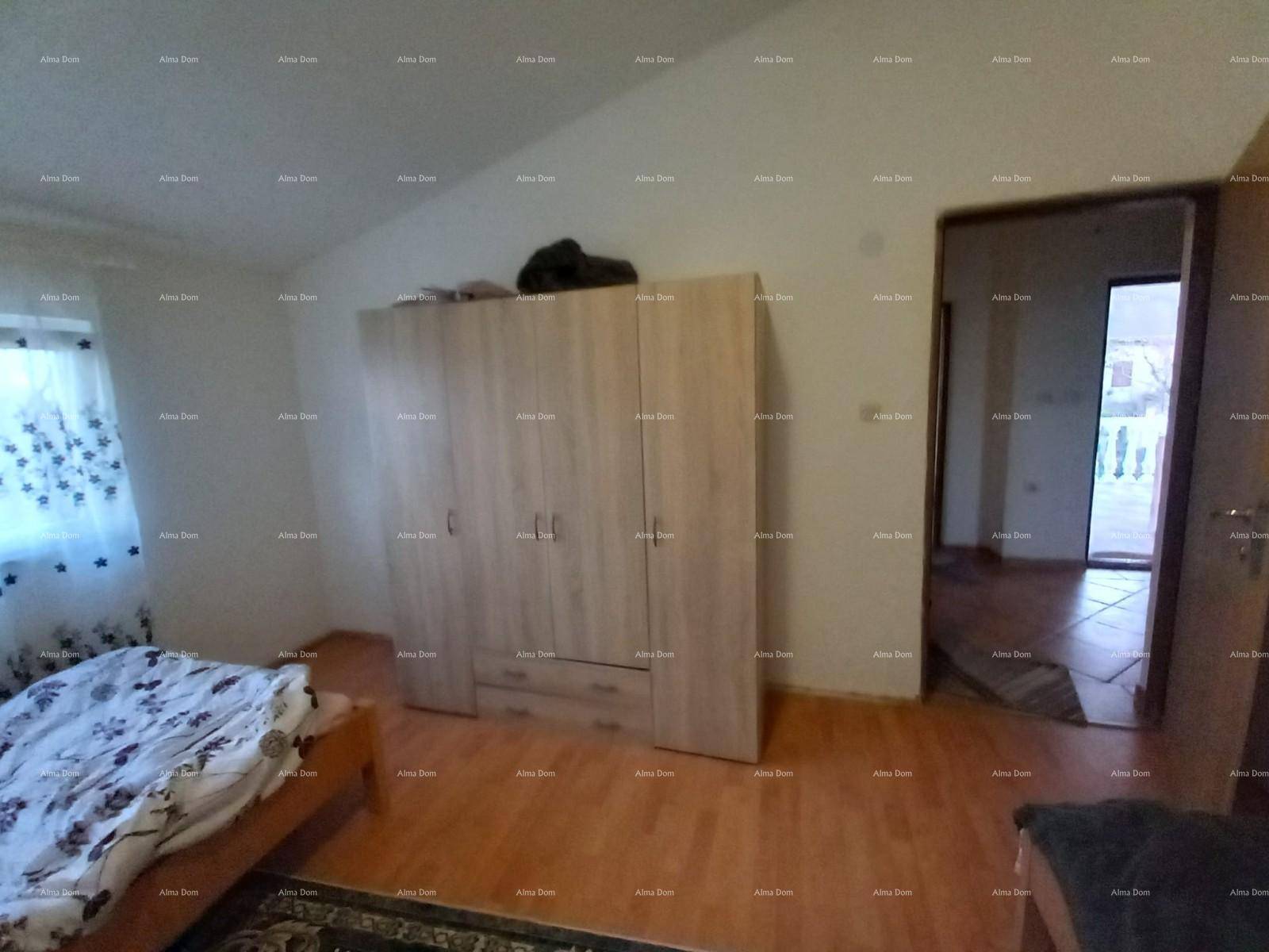 Schlafzimmer mit großem Kleiderschrank, Holzfußboden und Blick ins Freie durch die Tür.