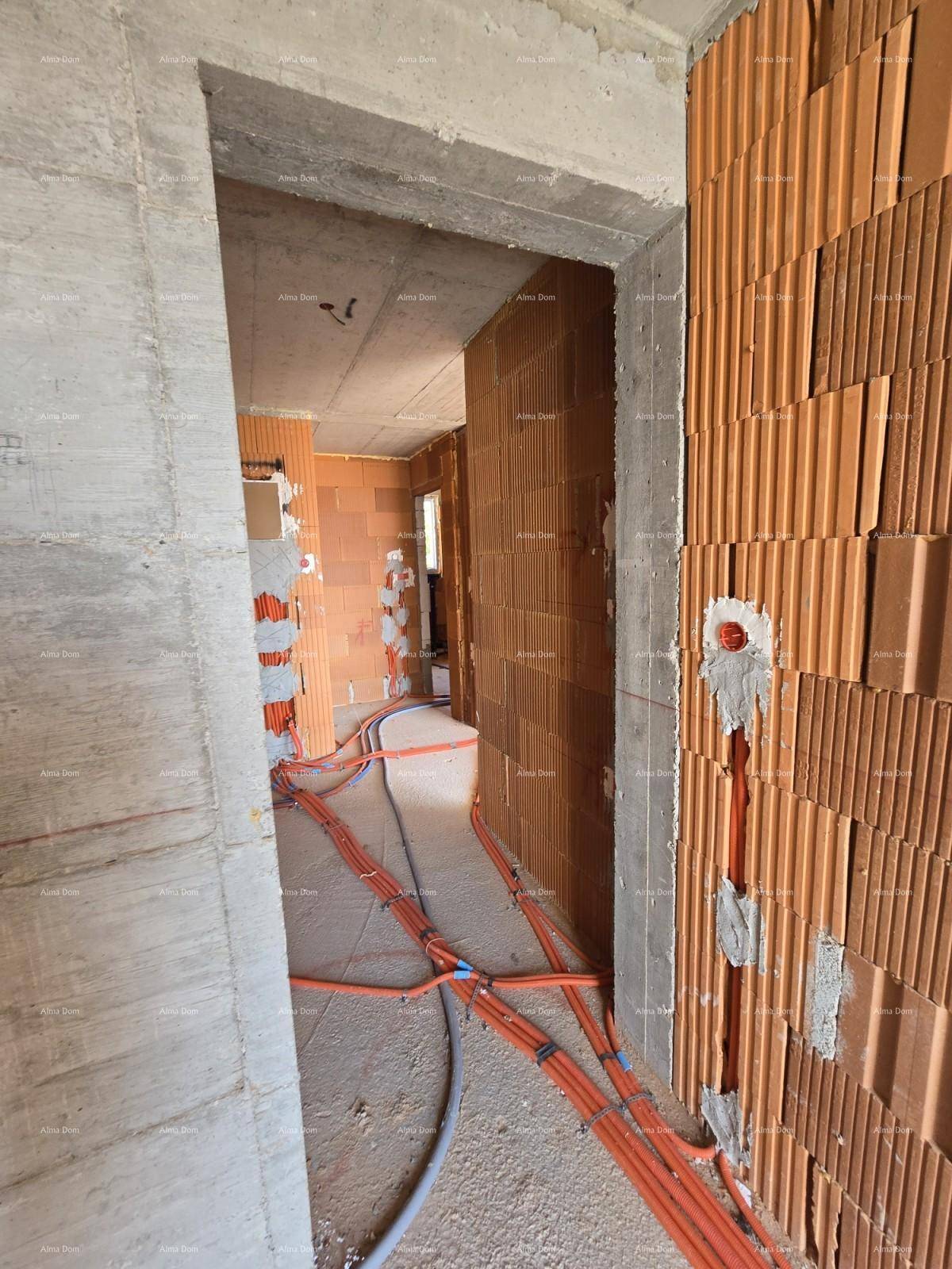 Innenansicht eines Rohbaus mit unverputzten Ziegelwänden, Betonboden und sichtbaren Elektroinstallationen im Flurbereich.