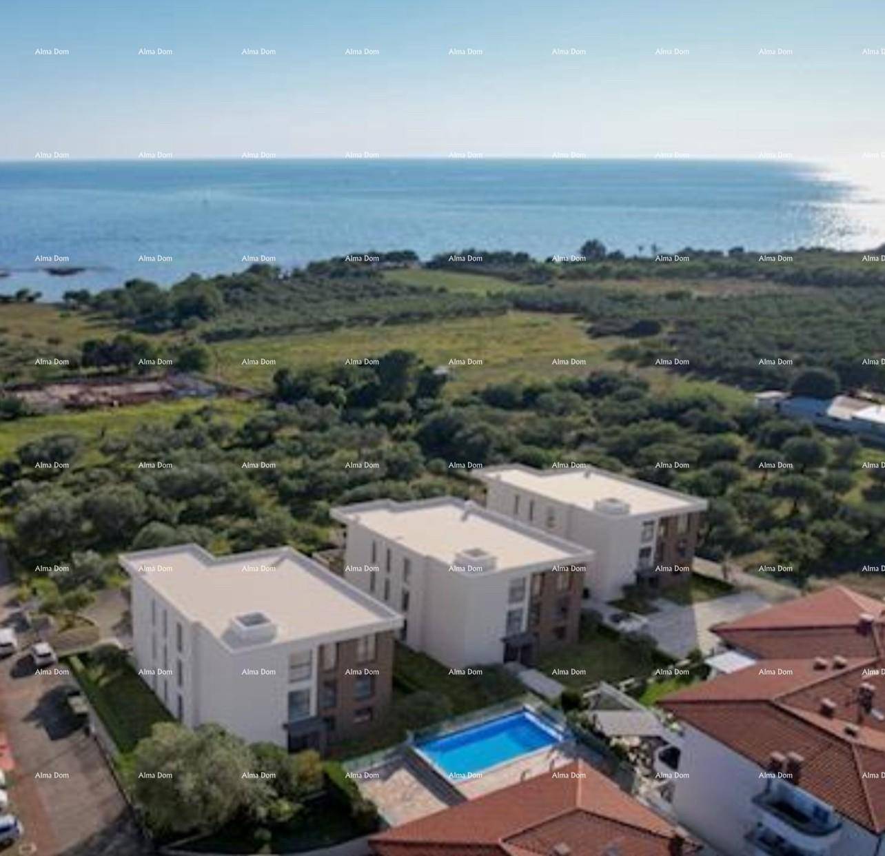 Luftaufnahme der modernen Wohnanlage mit Pool und Meerblick in der Ferne.