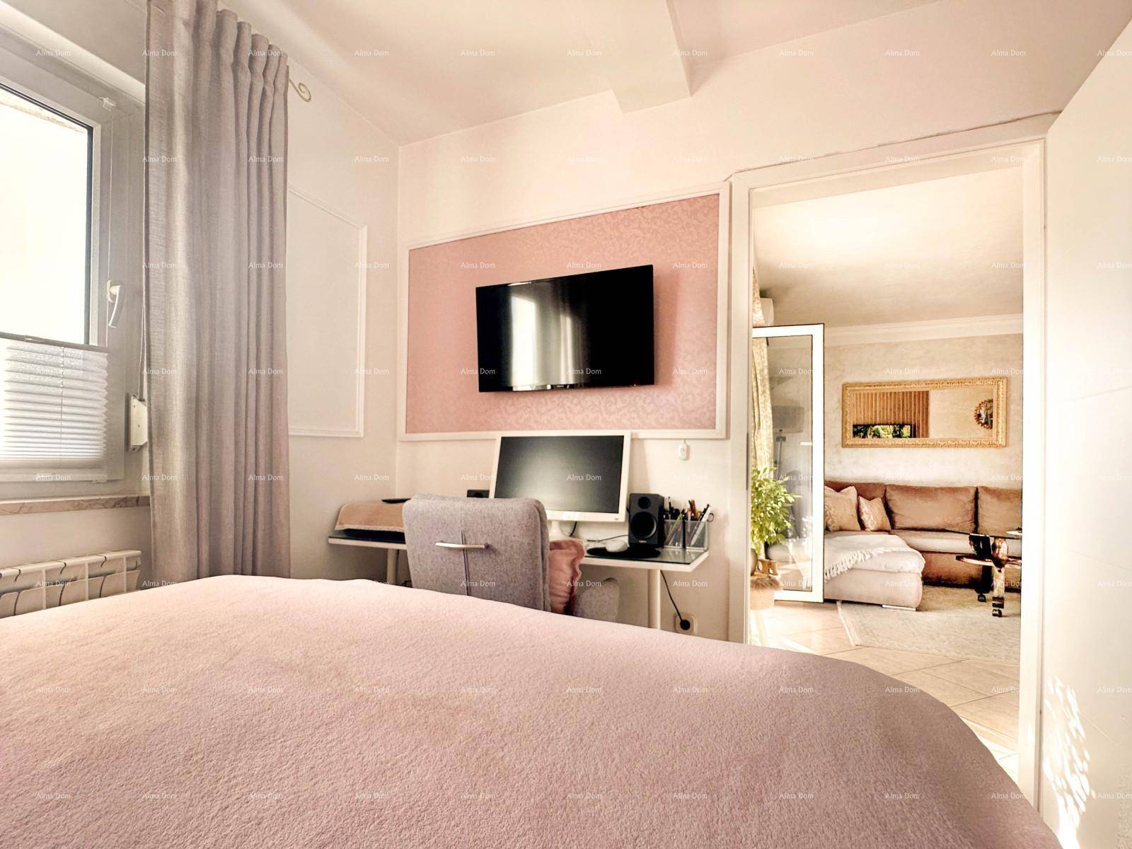 Schlafzimmer mit Bett, Arbeitsbereich und offenem Zugang zum Wohnzimmer.