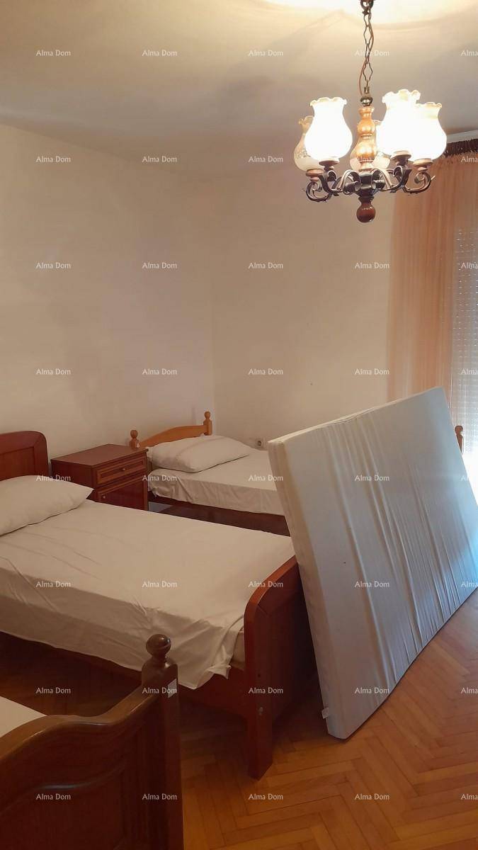 Schlafzimmer mit zwei Einzelbetten und Parkettboden, beleuchtet von einem klassischen Kronleuchter.