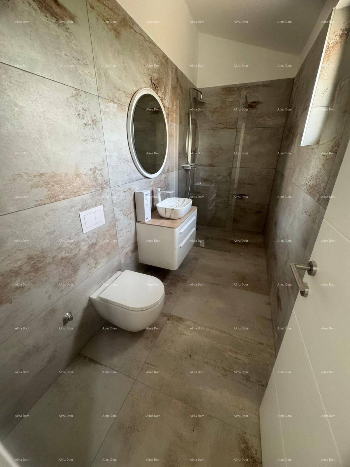 Modernes Badezimmer mit strukturierten Fliesen, schwebendem Waschtisch und Duschbereich.