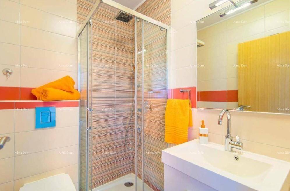 Modernes Badezimmer mit Duschkabine, Waschbecken und farbigen Fliesen in Orange und Beige.
