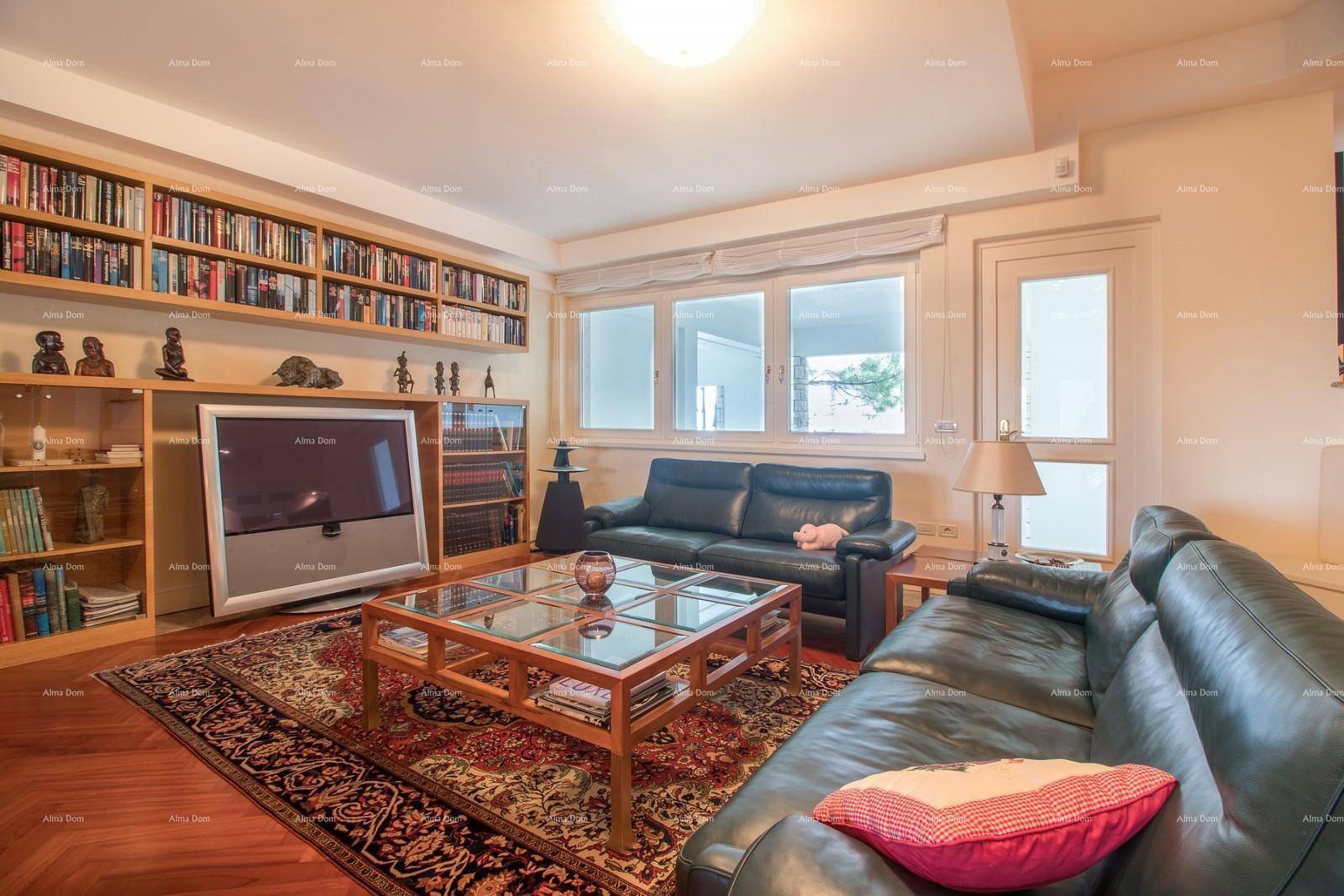 Gemütlicher Unterhaltungsraum mit Ledersofas, Bücherregalen und großem Fenster.