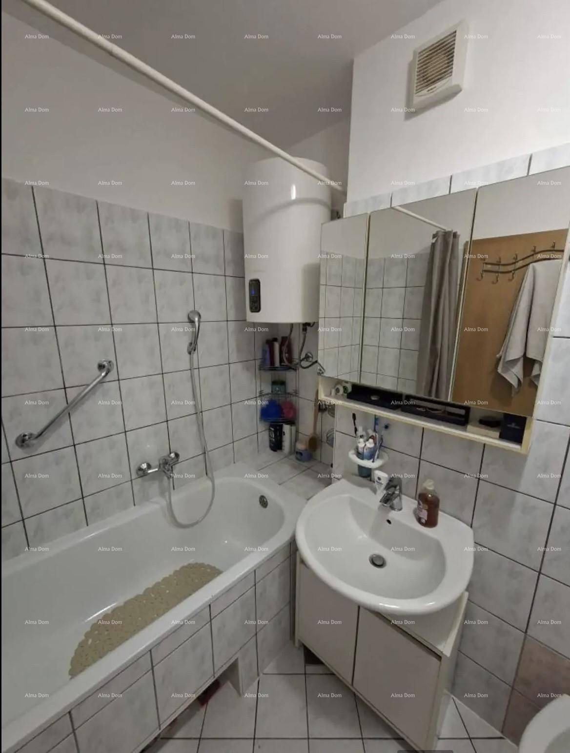 Badezimmer mit Badewanne, Waschbecken, Fliesen und praktischen Haltegriffen.