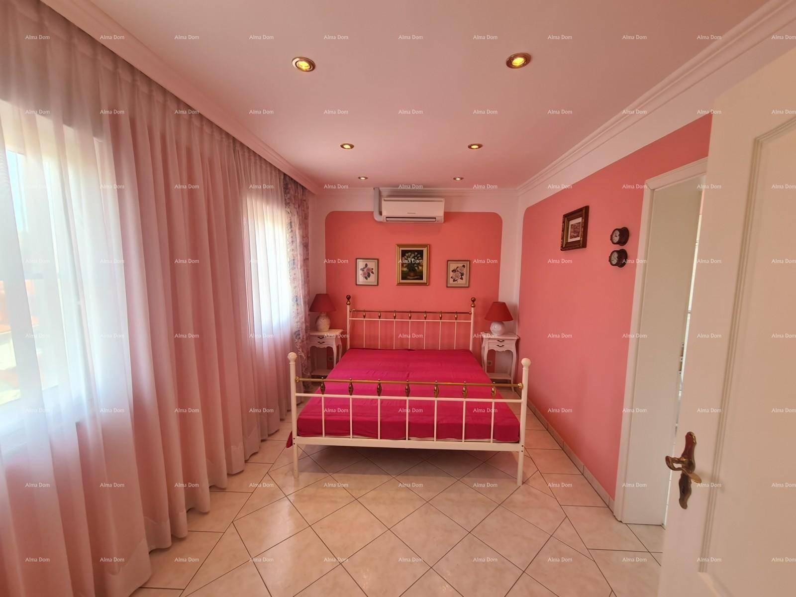 Schlafzimmer mit rosa Wänden, Doppelbett und Klimaanlage.