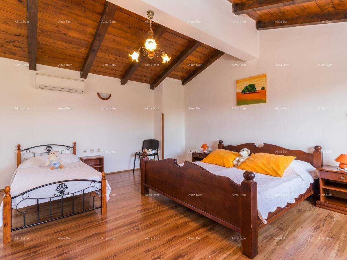 Gemütliches Schlafzimmer mit Holzbalkendecke, Holzboden und Klimaanlage.
