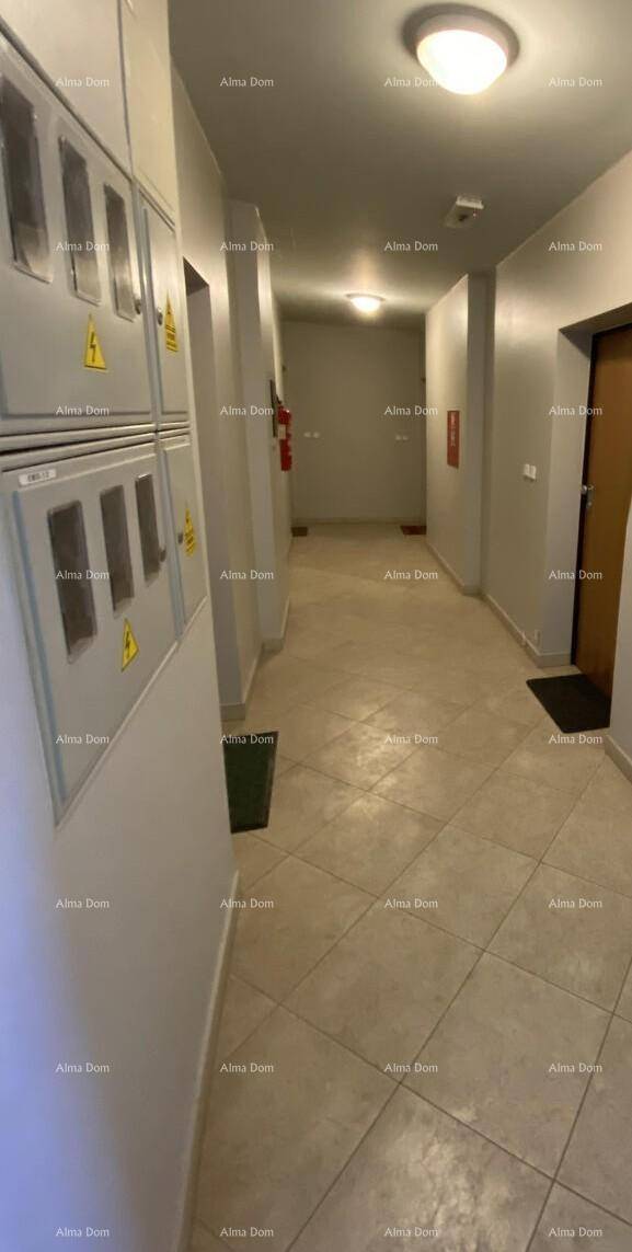 Langer Flur mit Fliesenboden und Zugang zu verschiedenen Räumen, ausgestattet mit Elektroschränken.