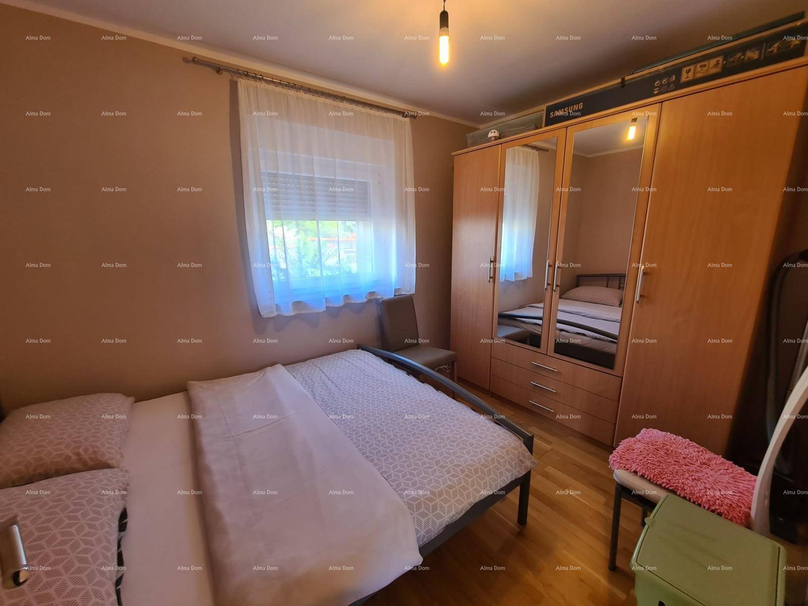 Schlafzimmer mit Doppelbett, großem Kleiderschrank mit Spiegeltüren und Holzboden.