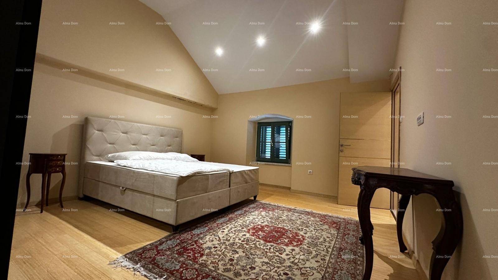 Helles Schlafzimmer mit Doppelbett, Holzboden, schräger Decke und Fenster mit Fensterläden.