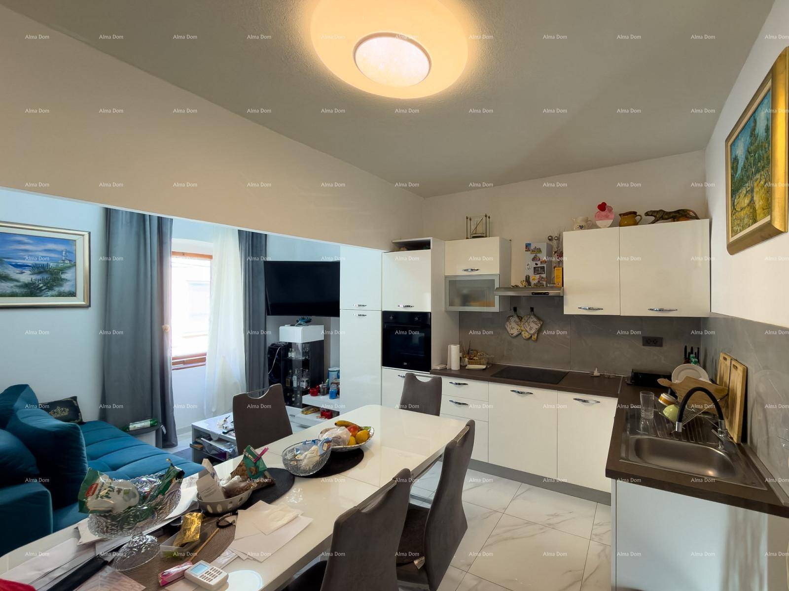 Helle Küche mit weißen Schränken, Essbereich und Blick auf das Wohnzimmer.