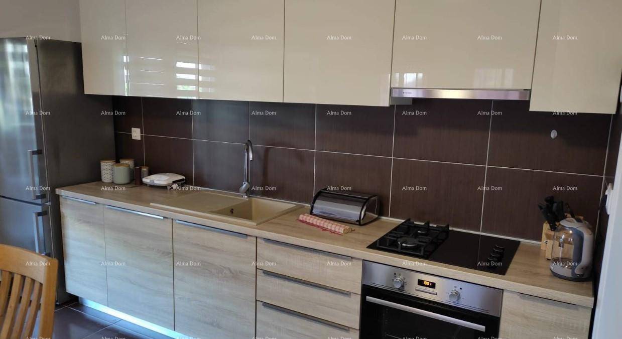 Detailansicht der modernen Küche mit Gasherd, Backofen, Spüle und integrierten Geräten.